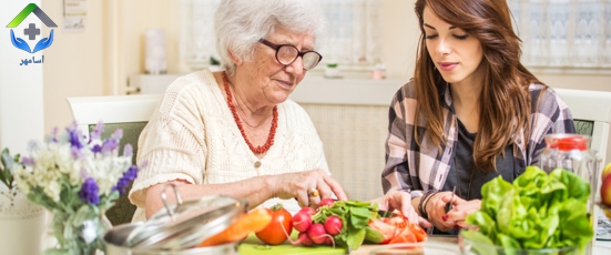 Grandmother and granddaughter preparing food together at kitchen.